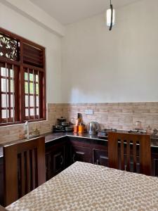 a kitchen with a table and a counter top at Sasmika Villa Surf and Yoga Hostel in Weligama