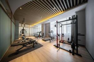 a gym with several treadmills and exercise bikes at Rezen Hotel Huaxia Xiamen in Xiamen