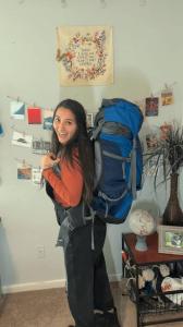 a woman standing in a room with a backpack at Nathaliya Home Stay For Backpackers in Negombo