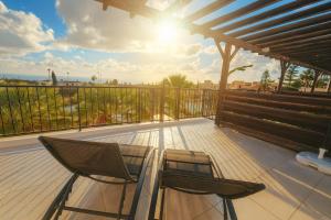 a patio with two chairs and a table on a deck at Dailon Oasis in Peyia