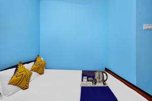 Habitación con cama con almohadas amarillas y blancas. en Hotel O Singh Guest House, en Calcuta