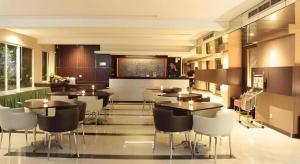 Un restaurante con mesas y sillas en una sala. en ZUZU Simpang Lima, en Semarang