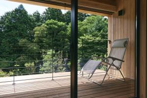 a rocking chair sitting on a screened in porch at GEOSPOT Motohakone A 2025年10月 New Open in Hakone