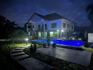 a white house with a swimming pool at night at Theorenda house in Ban Taling Ngam +5 photos