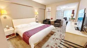 a bedroom with a large bed and a living room at Super8 Hotel Anyang Hongqi Road in Anyang