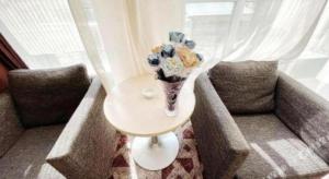 a vase of flowers sitting on a table next to two chairs at Super8 Hotel Anyang Hongqi Road in Anyang