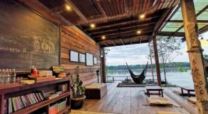 a room with a view of the water and a hammock at Suneta Hostel Chiangkhan in Chiang Khan