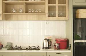 a kitchen counter with a stove and a tea kettle at Dirumahbandung in Sarireja