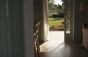 a wooden chair sitting in front of a door at Dirumahbandung in Sarireja