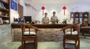 two men standing at a counter in a restaurant at Oriental Hotel in Dongguan