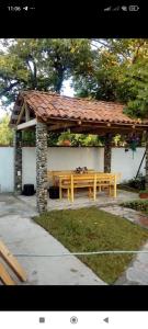 un banco de madera con un cenador en Rusalka, en Kobuleti