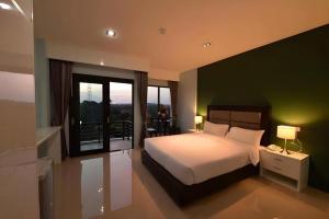 a bedroom with a large bed and a balcony at Sixty-Sixplace in Ban Khok Lo