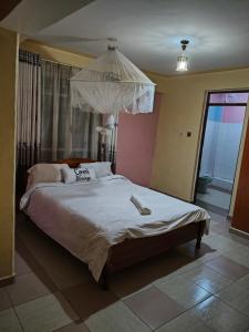 a bedroom with a large bed with a chandelier at Balozi Luxury Homes in Nanyuki