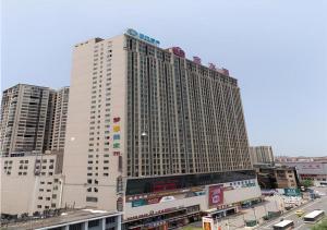 un grand bâtiment blanc dans une ville avec des bâtiments dans l'établissement City Comfort Inn Yongzhou Jinshuiwan, à Guzhuting