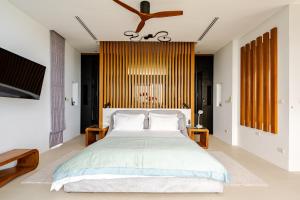 a bedroom with a large bed and wooden walls at Magic suites Seaview villas, Koh Samui in Choeng Mon Beach +22 photos