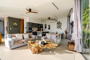 a living room with a couch and a table at Magic suites Seaview villas, Koh Samui in Choeng Mon Beach