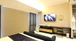 a bedroom with a bed and a tv on the wall at Fitra Hotel Majalengka in Majalengka