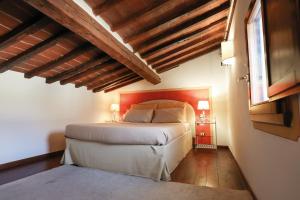 een slaapkamer met een bed in een kamer met houten plafonds bij Apartment San Frediano in Florence