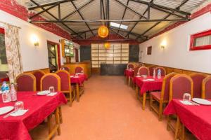 um restaurante com mesas vermelhas e cadeiras com toalha de mesa vermelha em Hotel Norbu Sangpo em Catmandu