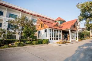 a building with a red roof on a street at Silayok Grand Hotel in Tak