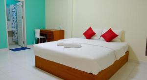 a bedroom with a large bed with red pillows at Matta Lodge Bali in Jimbaran