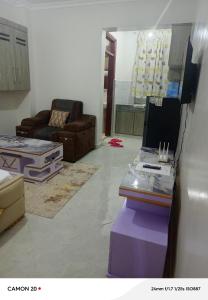 un salon avec un canapé et un ordinateur portable sur une table dans l'établissement Prift Royal Apartments, à Meru