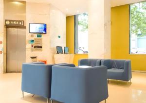 a waiting room with blue chairs and a tv at City Comfort Inn Xianning Xian'an in Guanbuqiao