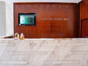 La salle de bains est pourvue d'une télévision murale et d'une baignoire. dans l'établissement City Comfort Inn Yichang Gezhouba CBD Shopping Center, à Yichang