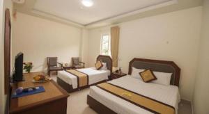 a hotel room with two beds and a television at Hai Long Hotel Cat Ba in Cat Ba +43 photos