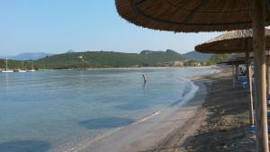 a person standing in the water on a beach at Splantza Apartments in Ammoudia