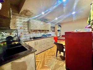 cocina con nevera roja y silla roja en Rajmahal Inn Dalhousie, en Dalhousie