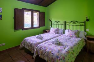 a bedroom with two beds and green walls at Aitxitxe in Carranza