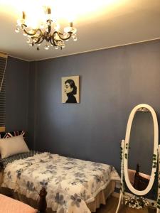 1 dormitorio con cama, espejo y lámpara de araña en sunset, en Jeonju