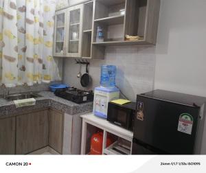 une petite cuisine avec un micro-ondes et un réfrigérateur dans l'établissement Prift Royal Apartments, à Meru