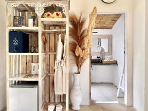 a room with a shelf with a vase and a mirror at Hot Stone Club Ubud in Ubud