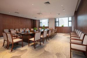 une grande salle à manger avec une longue table et des chaises dans l'établissement Rezen Hotel Pasonda Junyu, à Ho-tung