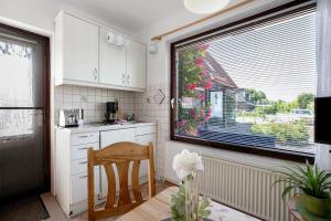 a kitchen with a window and a table and a chair at Gartenwohnung in Westerdeichstrich