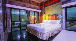 une chambre avec un grand lit et une grande fenêtre dans l'établissement Ps Extra Hotel, à Ban Kohong
