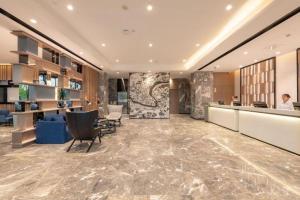 un hall d'un hôtel avec une réception et des chaises dans l'établissement Echarm Hotel Guilin North High Speed Railway Station, à Guilin