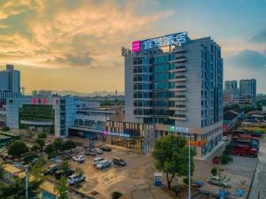 a tall building with a sign on top of it at Echarm Hotel Guilin North High Speed Railway Station in Guilin