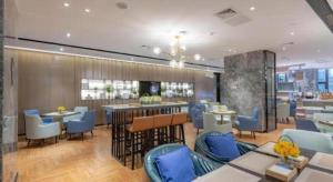 un restaurant avec des tables et des chaises bleues ainsi qu'un bar dans l'établissement Echarm Hotel Guilin North High Speed Railway Station, à Guilin