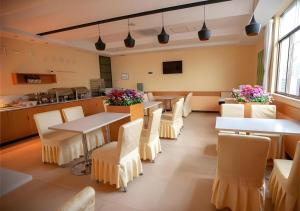 un ristorante con tavoli, sedie e un bancone di City Comfort Inn Hechi Du'an Wenti Square a Du’an