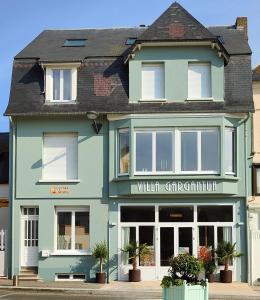 un grand bâtiment bleu avec une boutique en vitrine dans l'établissement VILLA GARGANTUA, à Cayeux-sur-Mer
