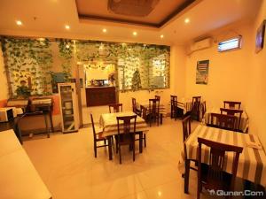 a restaurant with tables and chairs in a room at GreenTree Inn Tianjin Dasi Meijiang Huizhanzhongxin Business Hotel in Tianjin