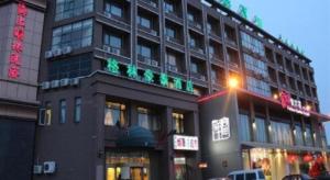 a tall building with a store on a city street at GreenTree Inn Tianjin Dasi Meijiang Huizhanzhongxin Business Hotel in Tianjin