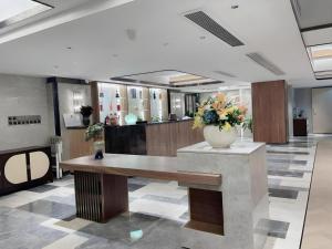 香港にあるShenzhen Hongfeng Hotel (Luohu Branch)のテーブルの上に花瓶が置かれたロビー