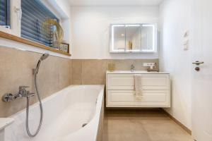 a bathroom with a tub and a sink and a mirror at bei Thérèse - Obergeschoss in Miltach +23 photos