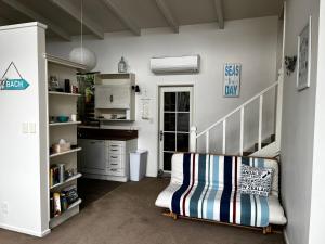 a living room with a staircase and a chair at Beachfront Tranquility in Tikao Bay in Wainui
