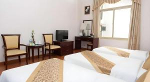 a hotel room with two beds and a table and a television at Cong Doan Viet Nam Hotel in Hanoi
