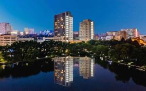 a city skyline with tall buildings and a body of water at Dajiuhua Hotel in Chizhou